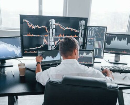 A day trader sits in front of a bunch of computer screens